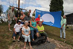 Stolz präsentieren die Mitglieder des Wassersportvereins Bergstraße e.V. die Blaue Flagge vor der Hissung.